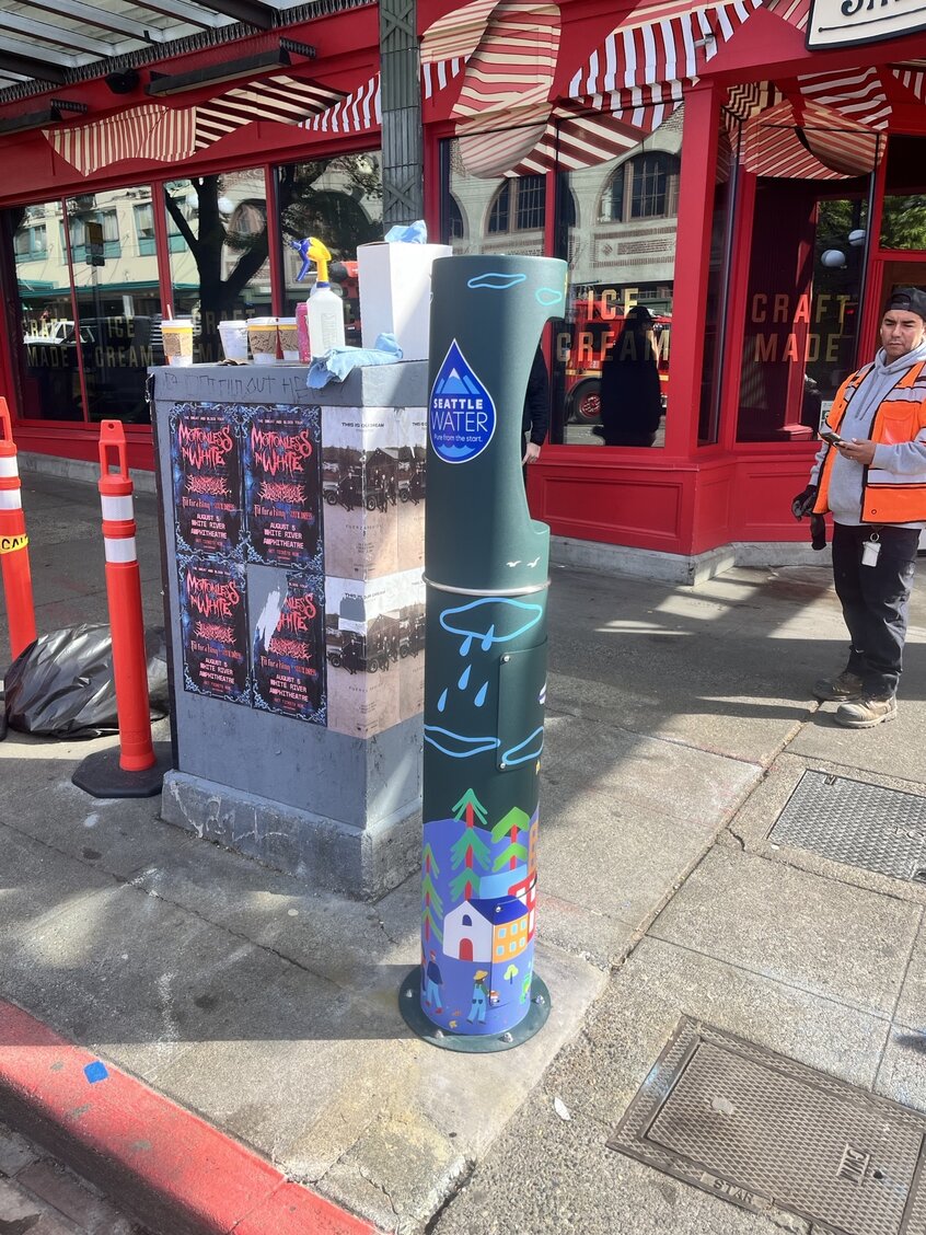 AlphaGraphics install team applying the wrap to a Seattle Public Utilities water refill station